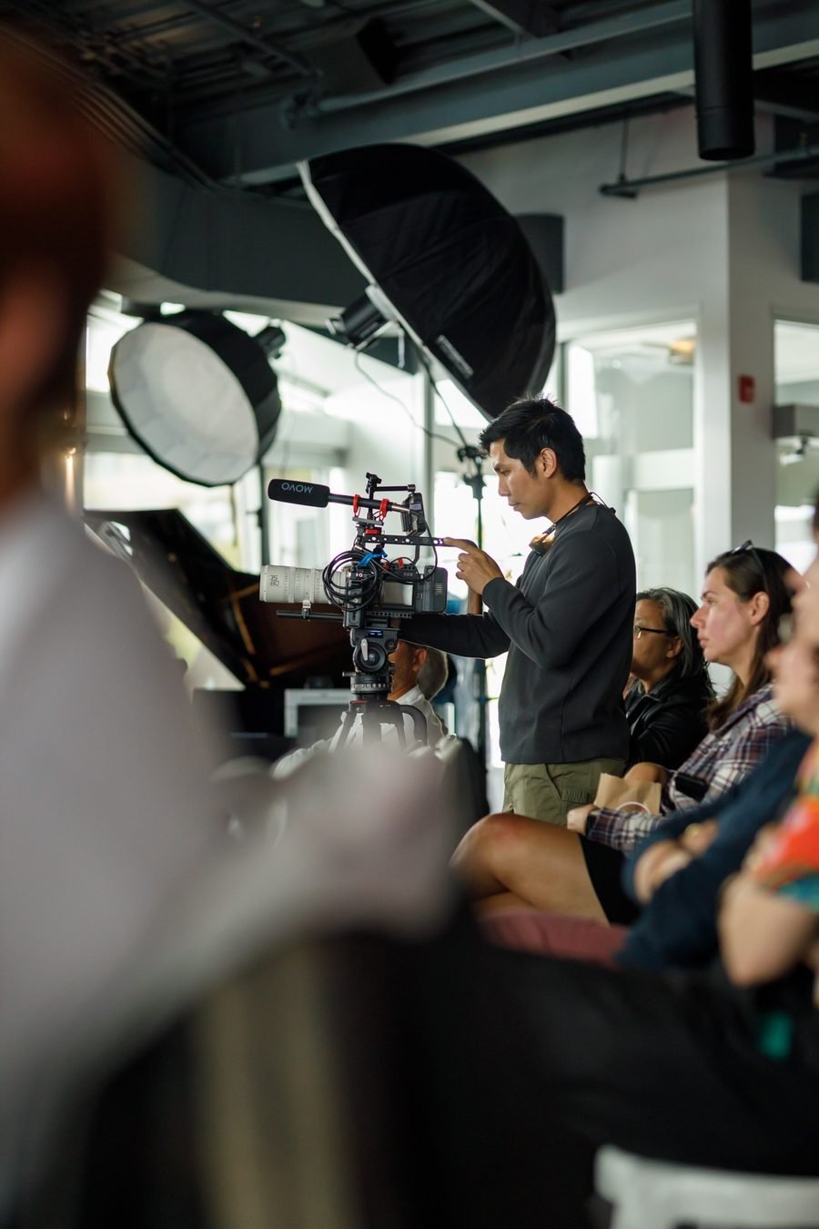 Volare Media camera operator filming a seated audience at a festival