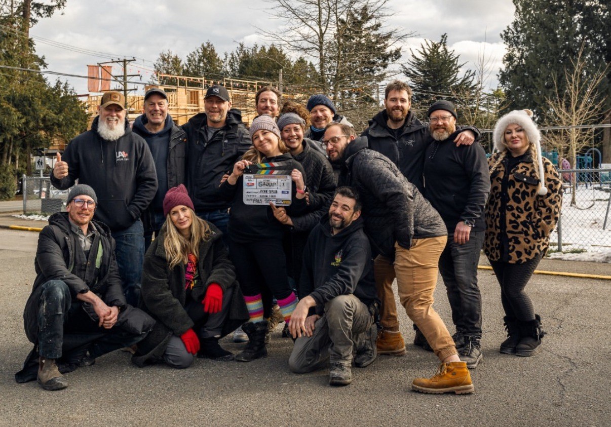 The full Volare Media production crew posing together with the film slate after a shoot in BC